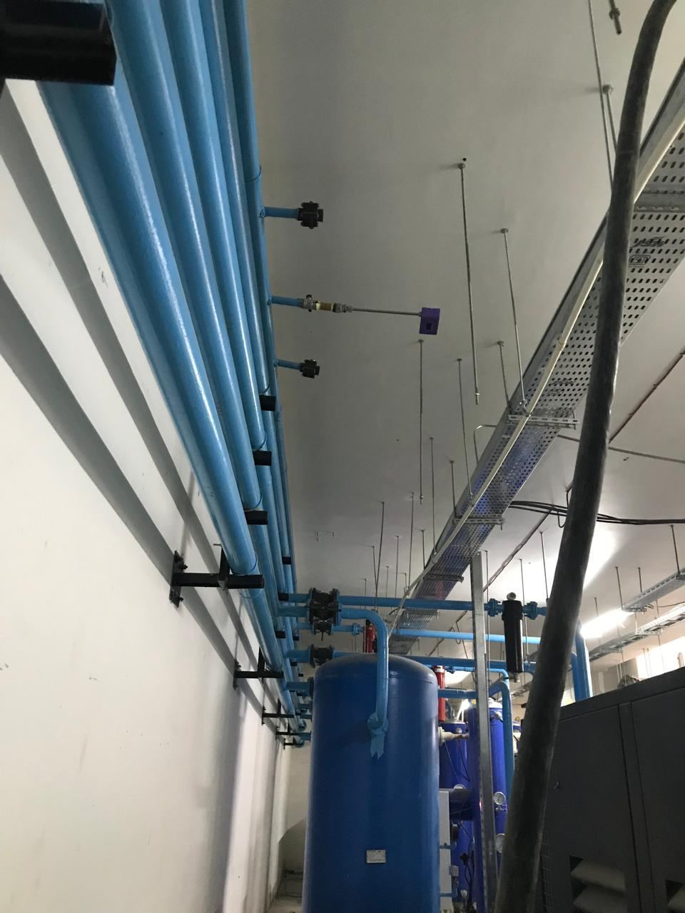 Compressed air piping installed along a plant room wall