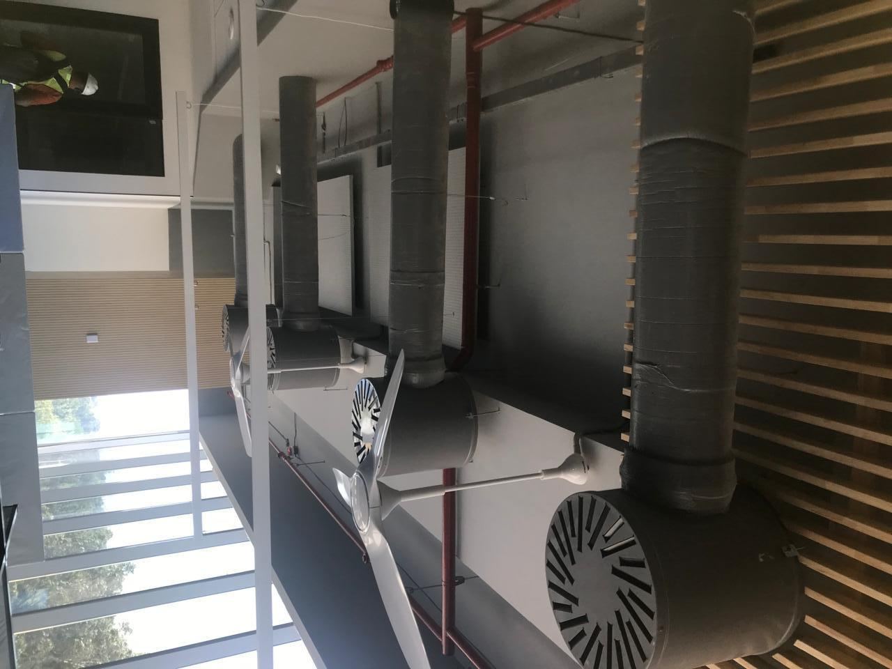 Ductwork and ceiling fans installed in an office workspace